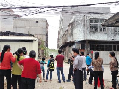 昨日，廣東普寧起火的內衣作坊巷口，很多人在圍觀起火居民樓。若不是很多家庭作坊停工，村里很難聚集這么多人。新京報記者 盧美慧 攝