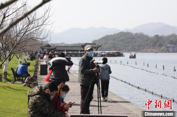 圖為市民游客在西湖邊游玩 王偉臣 攝